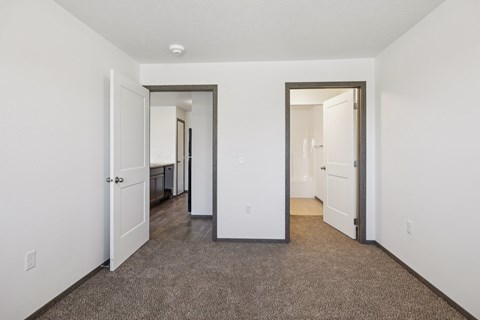 A hallway with carpeted floors and white walls.