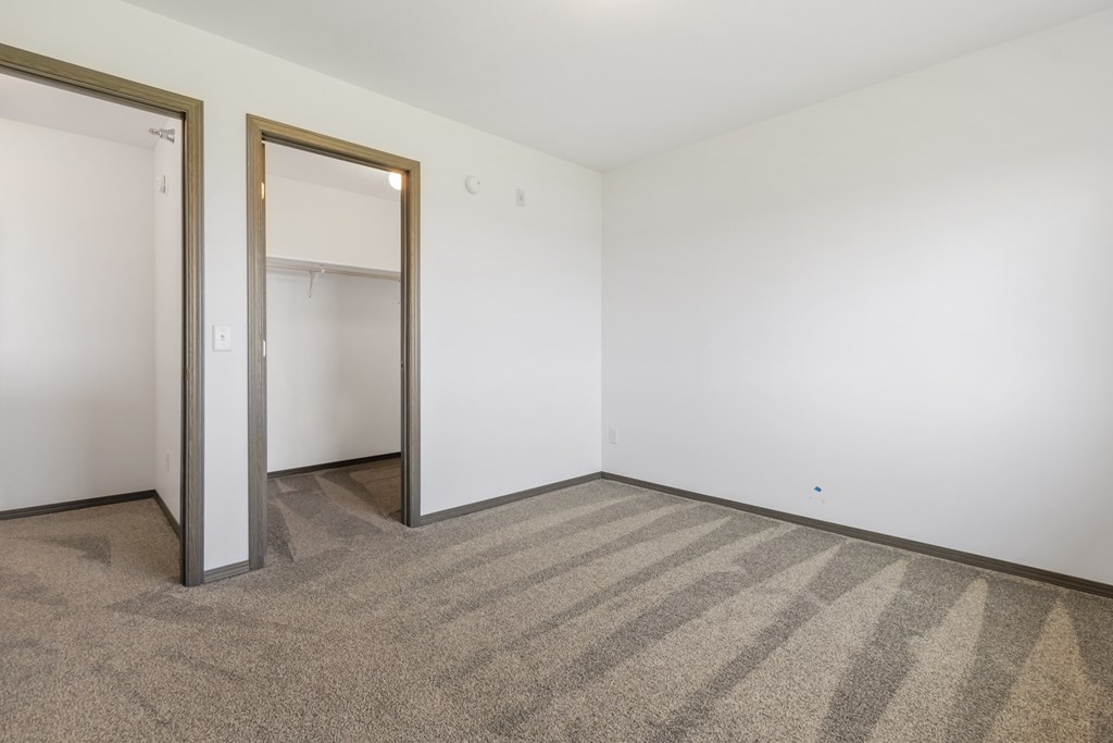 A room with a striped carpet and two open doors.
