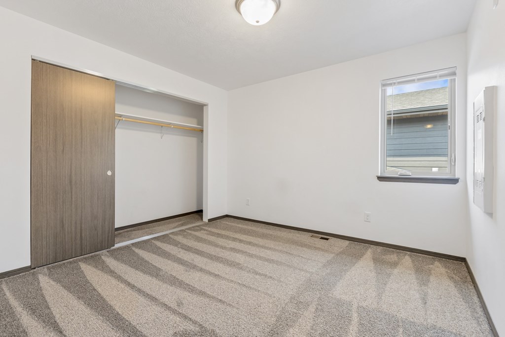 A room with a carpeted floor and a sliding door.