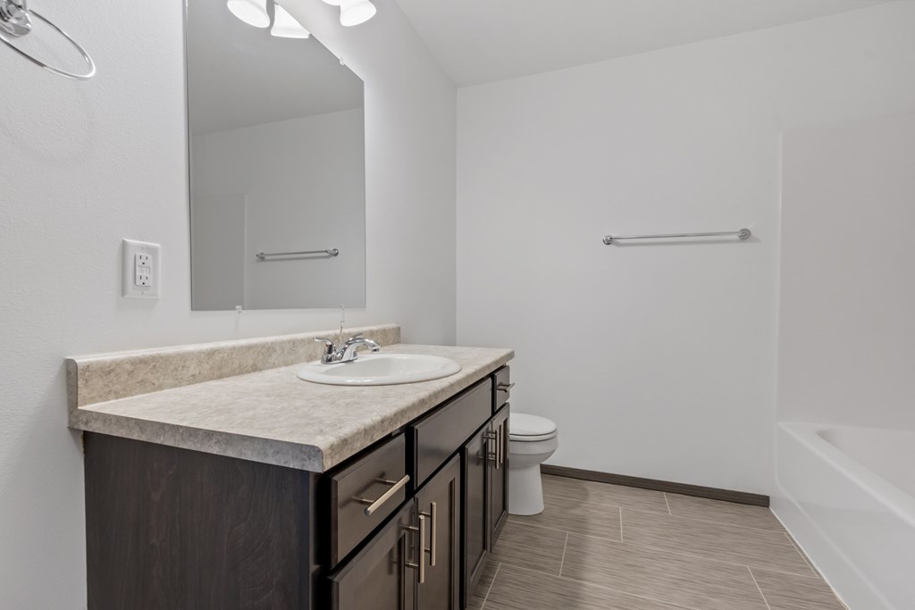 A bathroom with a sink, toilet, and bathtub.