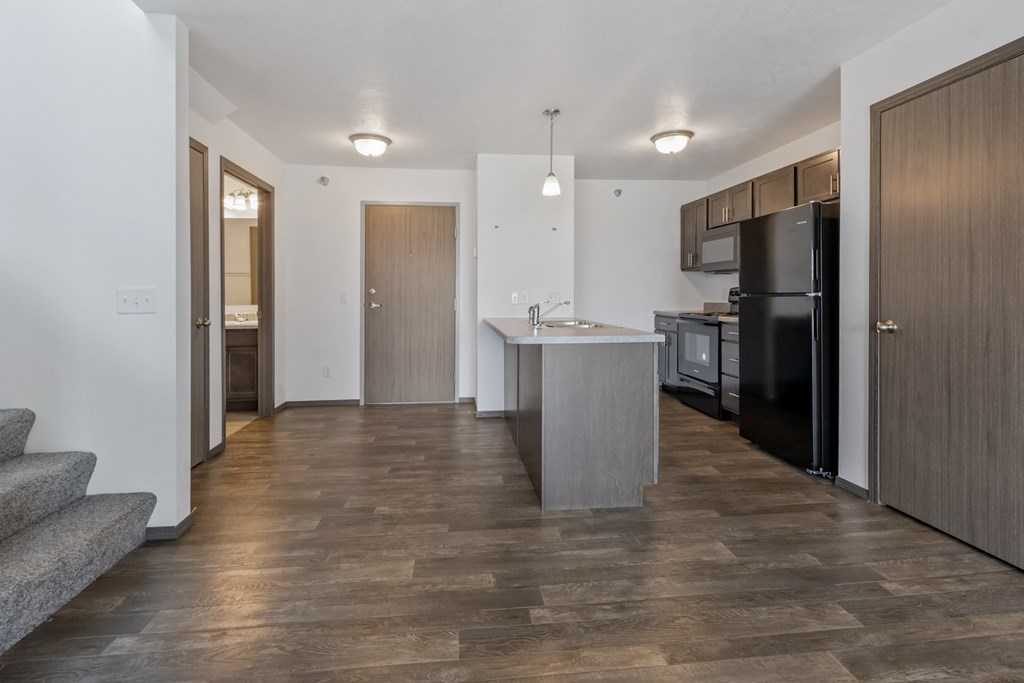 A modern kitchen with a refrigerator, sink, and cabinets.