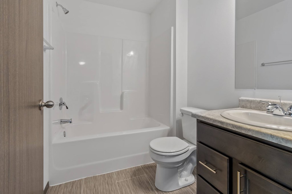A white toilet sits in a bathroom next to a sink.
