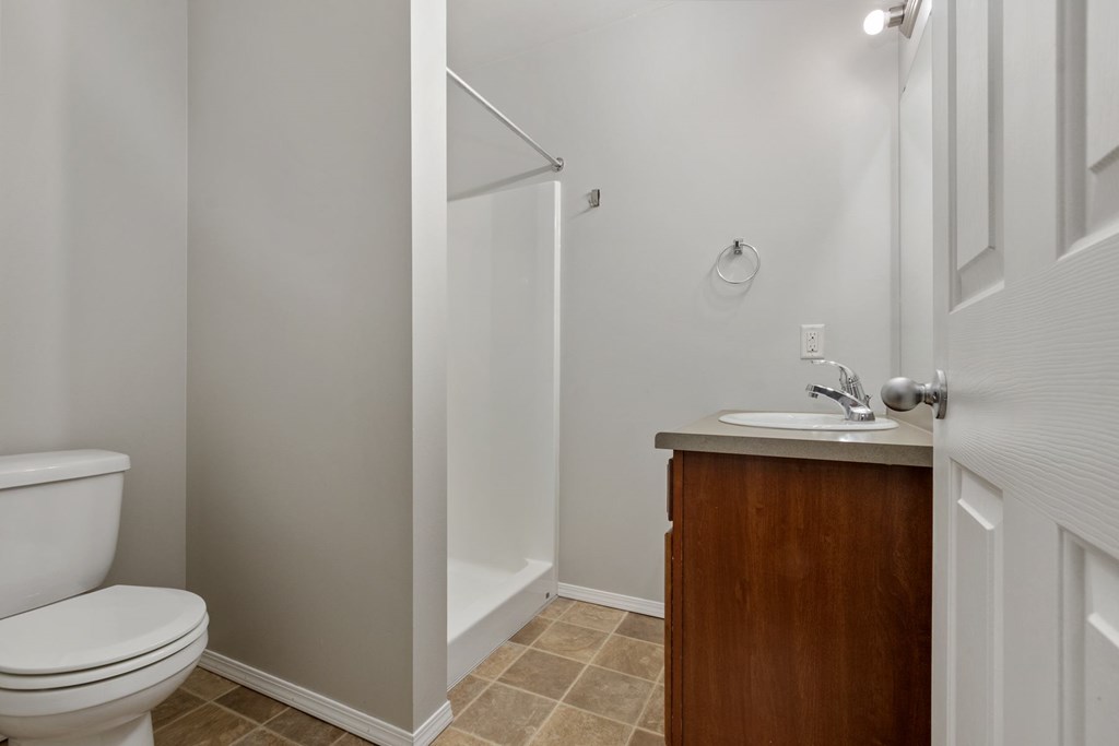 A white toilet sits next to a sink in a small bathroom.