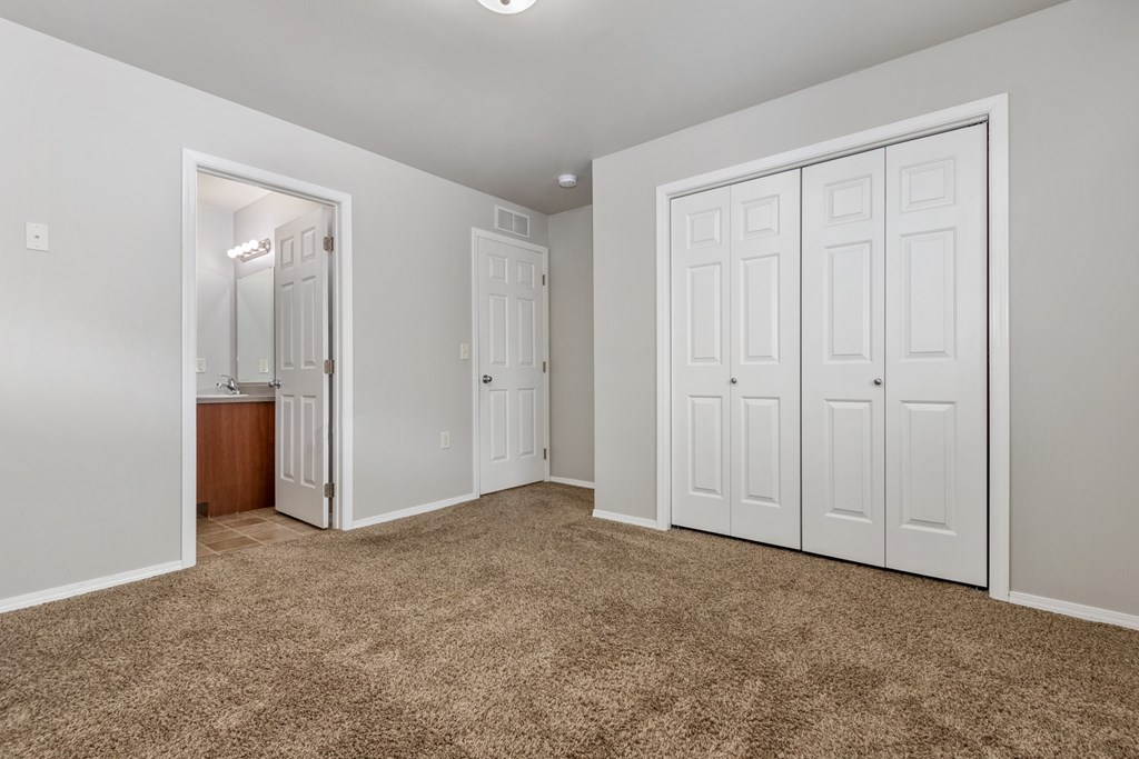 A room with white walls and brown carpet.