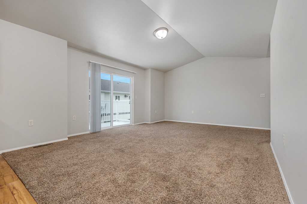 A room with a carpeted floor and a window.