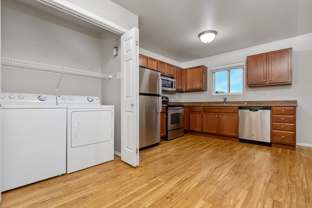 A kitchen with wooden floors and white appliances.