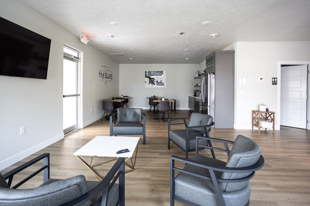 a living room with chairs and a table and a television