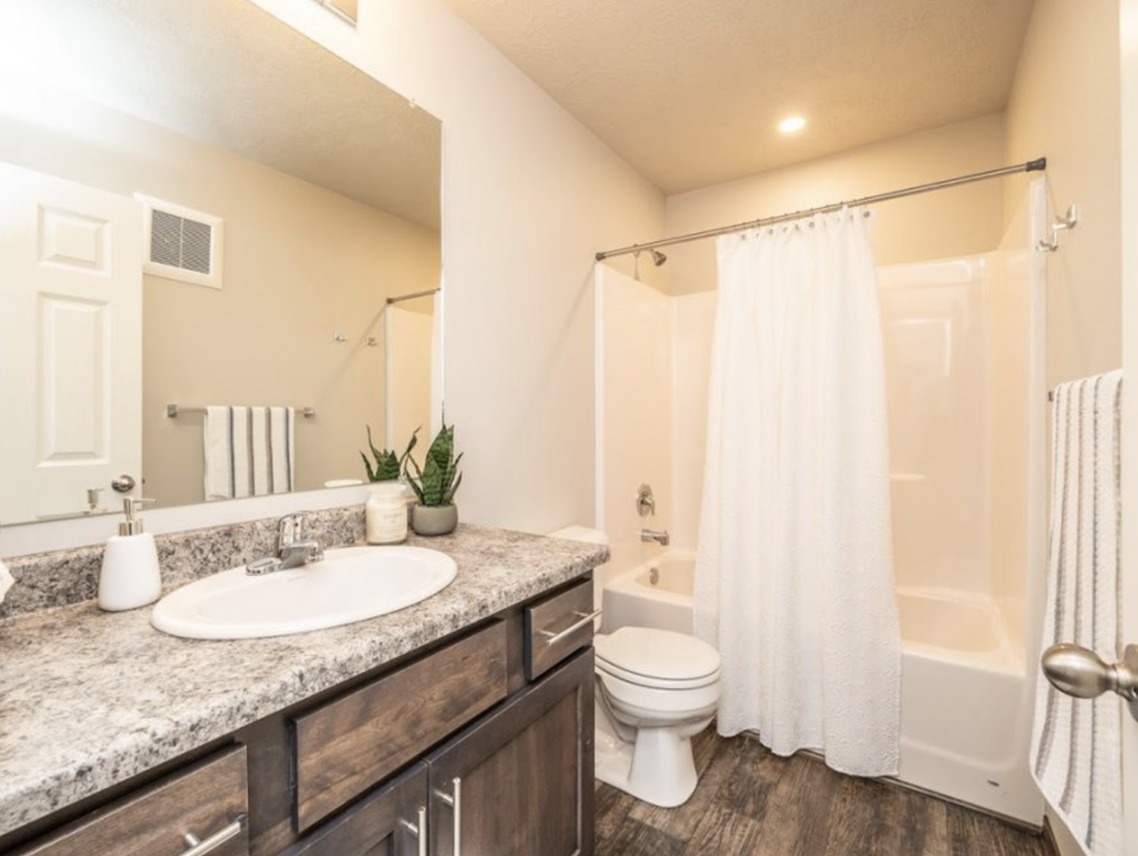a bathroom with a toilet and a sink and a shower