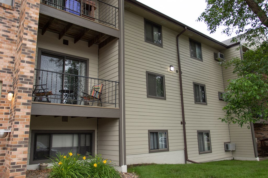 an apartment building with a balcony and a lawn