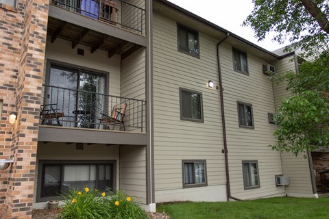 an apartment building with a balcony and a lawn