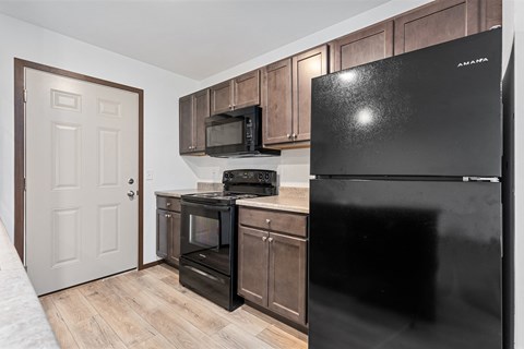 a kitchen with black appliances and wooden cabinets