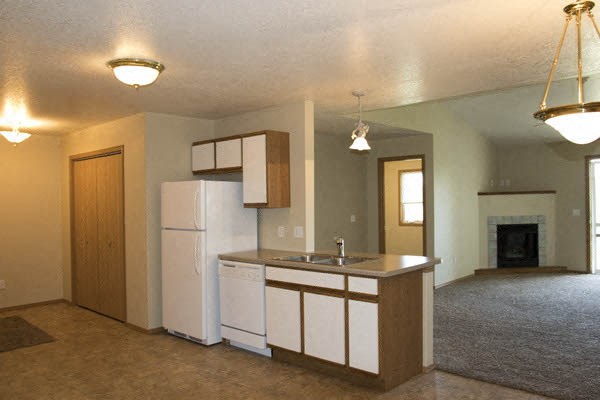 an empty kitchen with a refrigerator and a sink