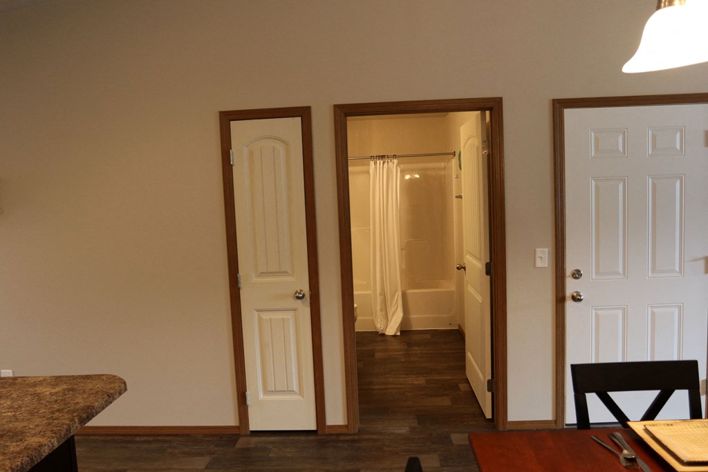 the view from the kitchen into the living room and the hallway to the bedroom