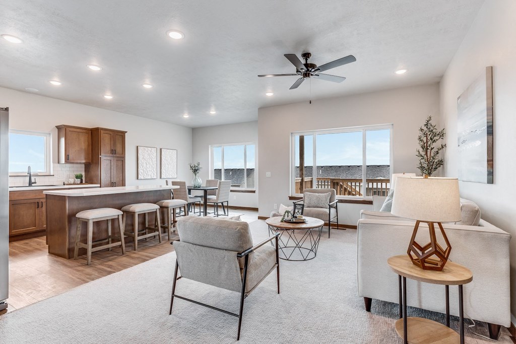 a living room with a kitchen and a ceiling fan