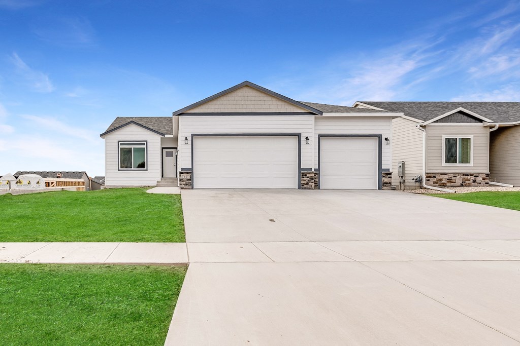 a white house with two garage doors and a driveway