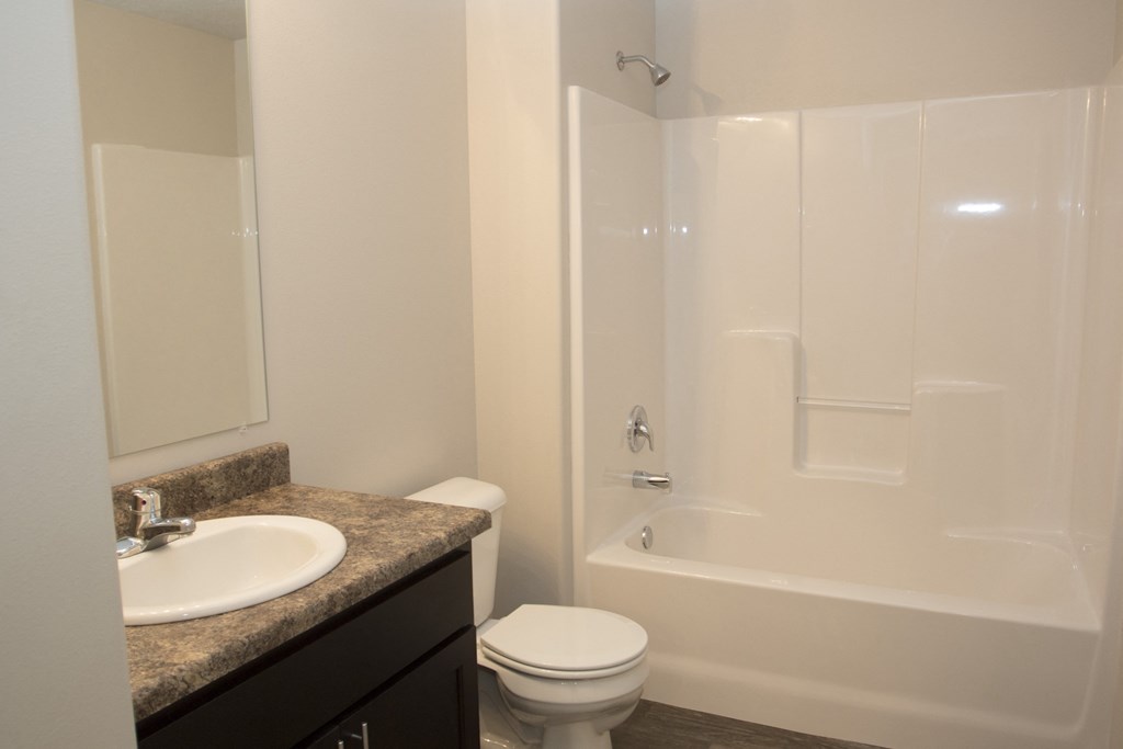 an empty bathroom with a sink toilet and shower
