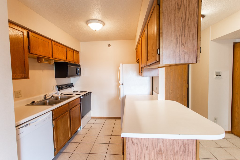 an empty kitchen with a sink and a refrigerator