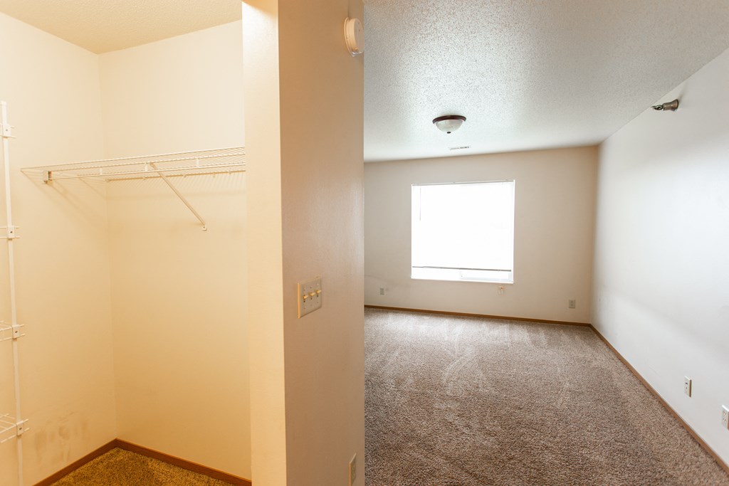 an empty room with a closet and a window