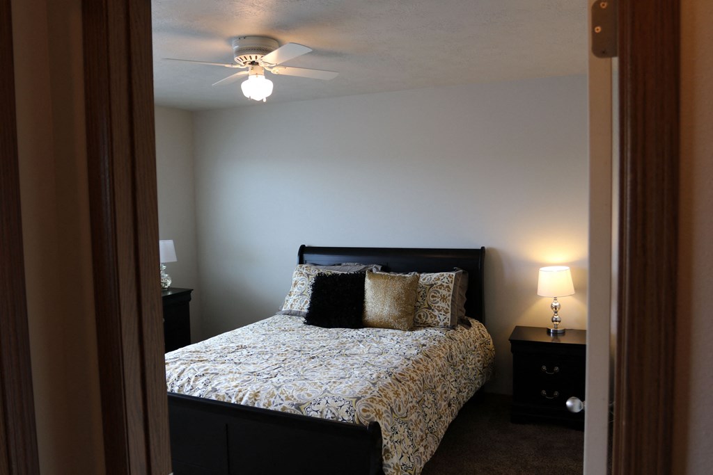 a bedroom with a bed and a ceiling fan
