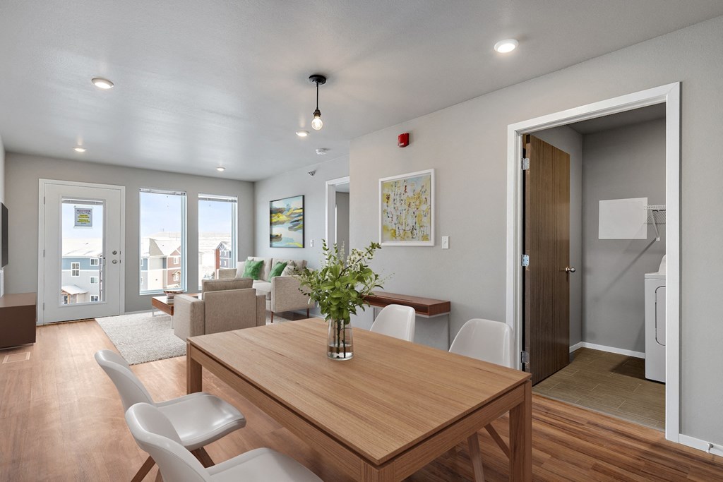a living room and dining room with a wooden table and chairs