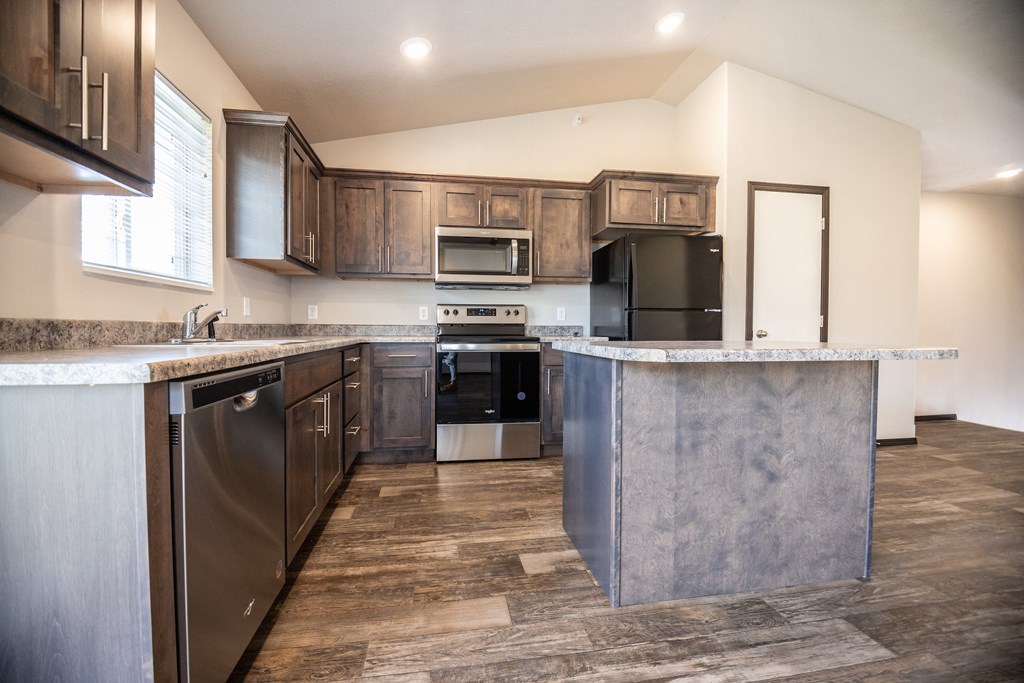 an updated kitchen with stainless steel appliances and marble counter tops