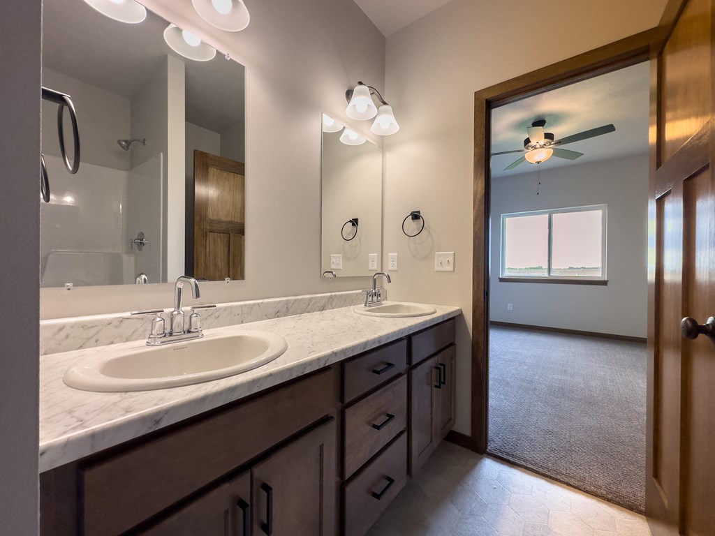 the master bathroom has dual sinks and a large mirror