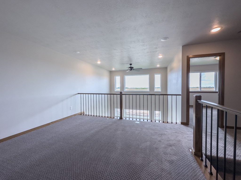the upstairs loft has a large window and a railing