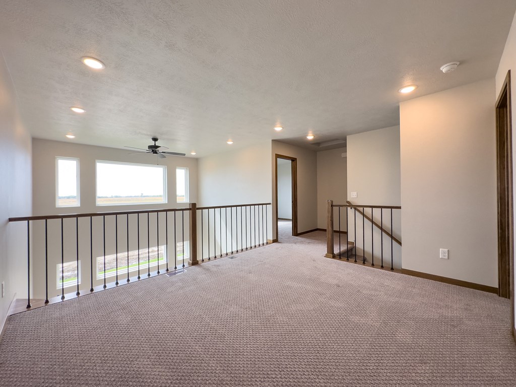 the upstairs loft has a large window and a railing
