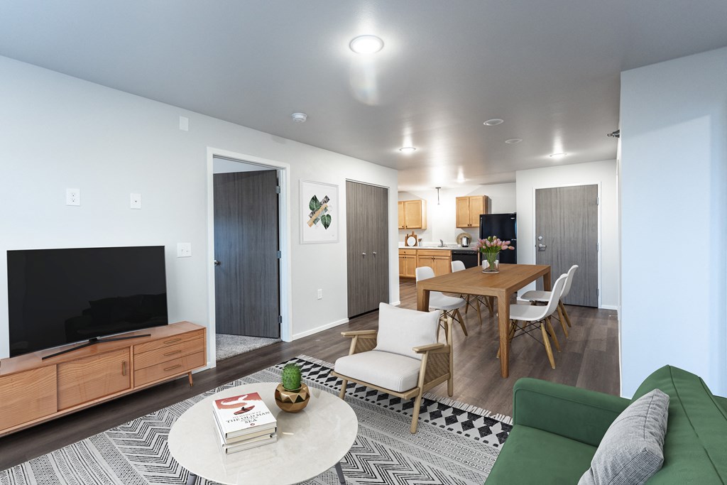 a living room and dining room with a table and a television