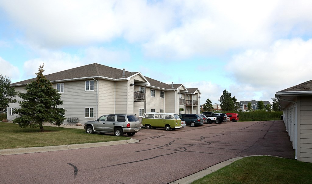 a row of houses with cars parked in front of them