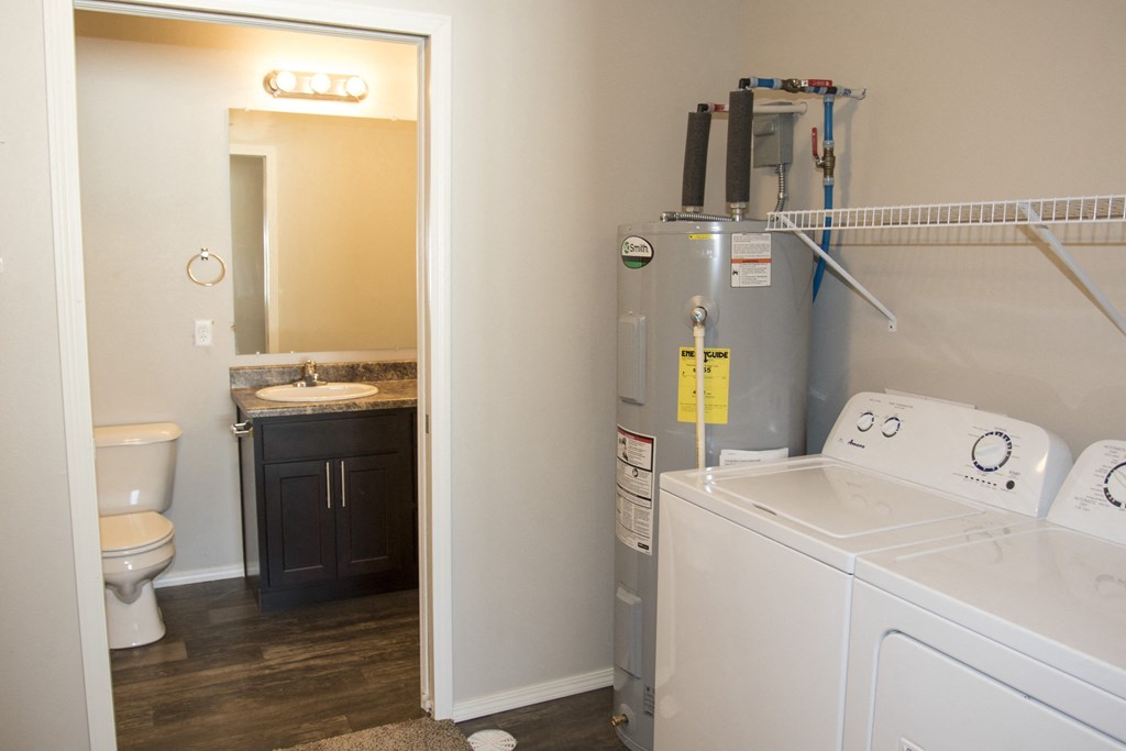 a laundry room with a washer and dryer and a toilet and a sink