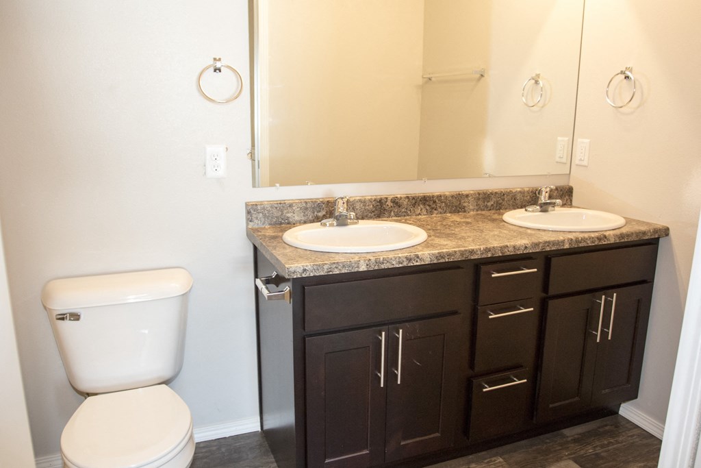 an empty bathroom with two sinks and a toilet