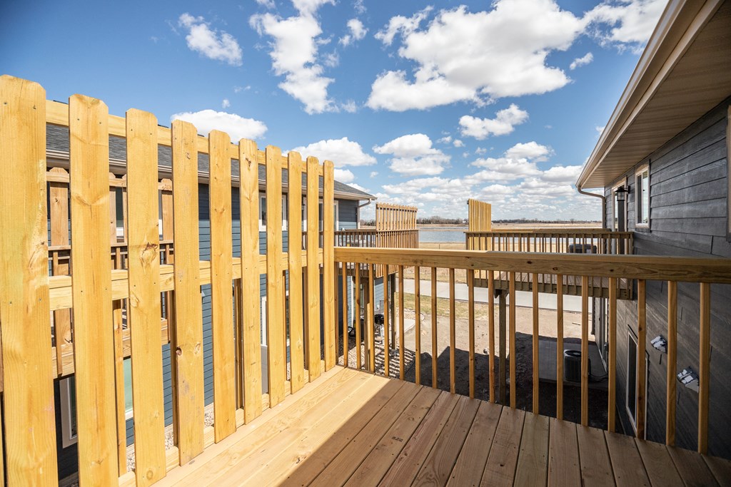 a deck with a view of the water and a wooden fence
