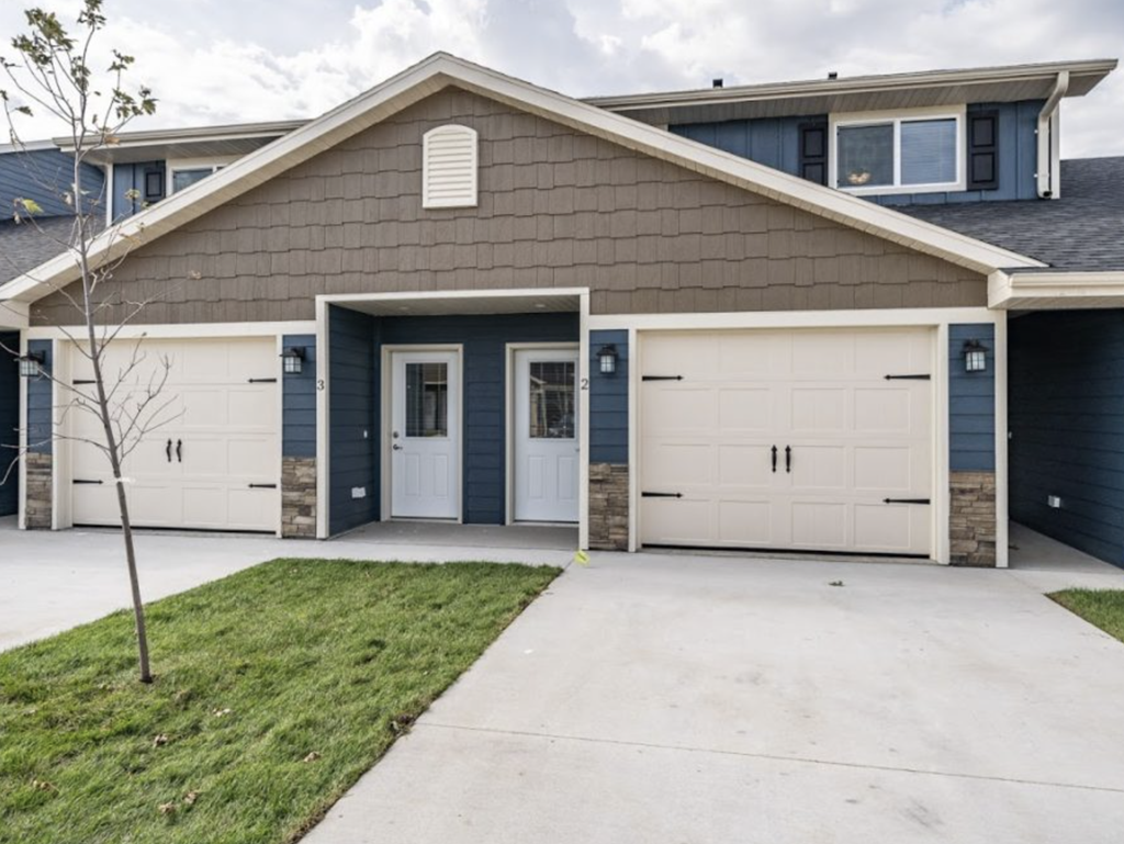 the front of a house with white garage doors