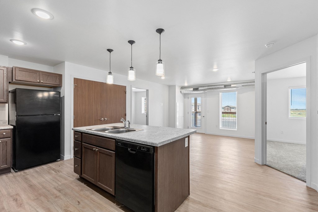 a kitchen with a large island and a black refrigerator