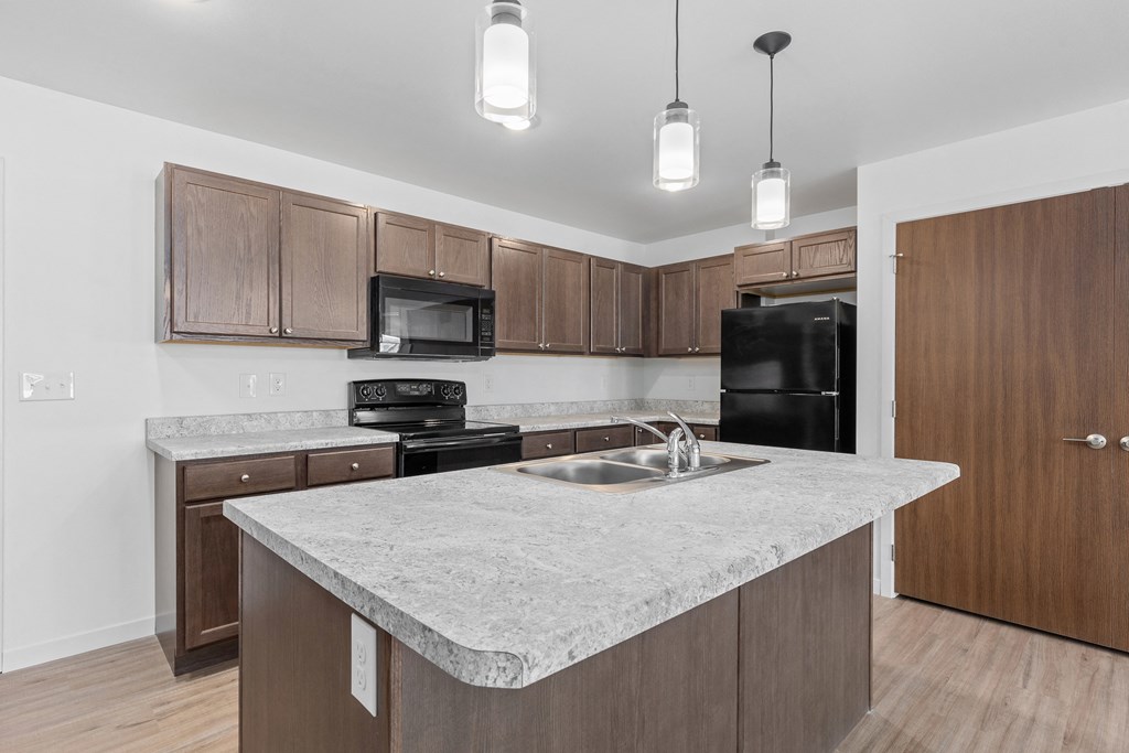 a kitchen with a marble counter top and wooden cabinets