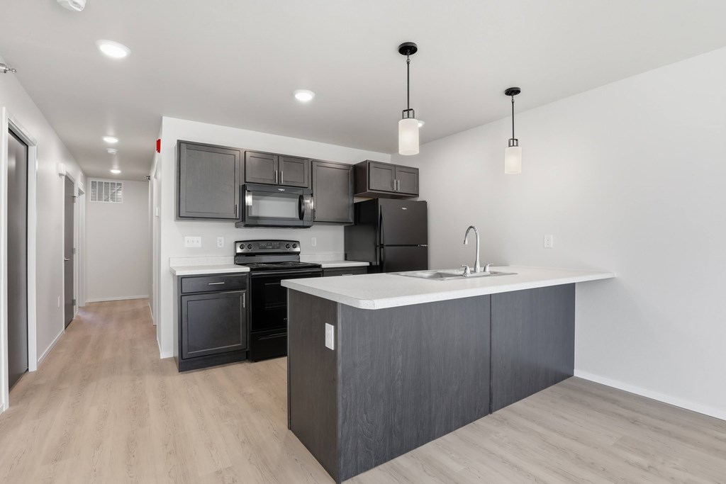 A modern kitchen with a large island and stainless steel appliances.