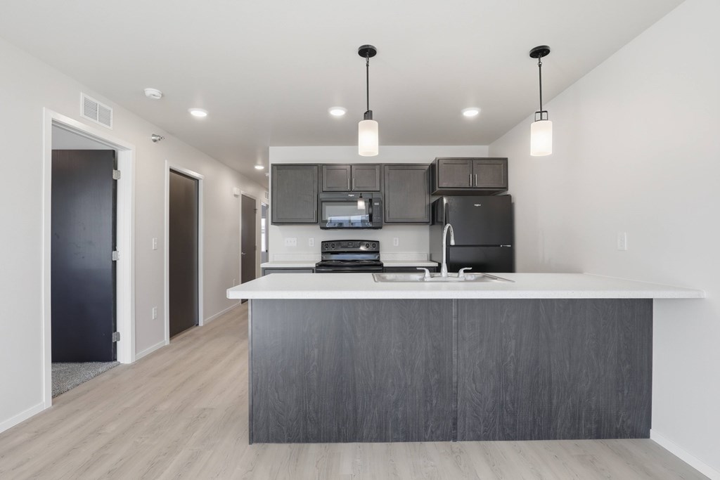 A modern kitchen with a large island and stainless steel appliances.