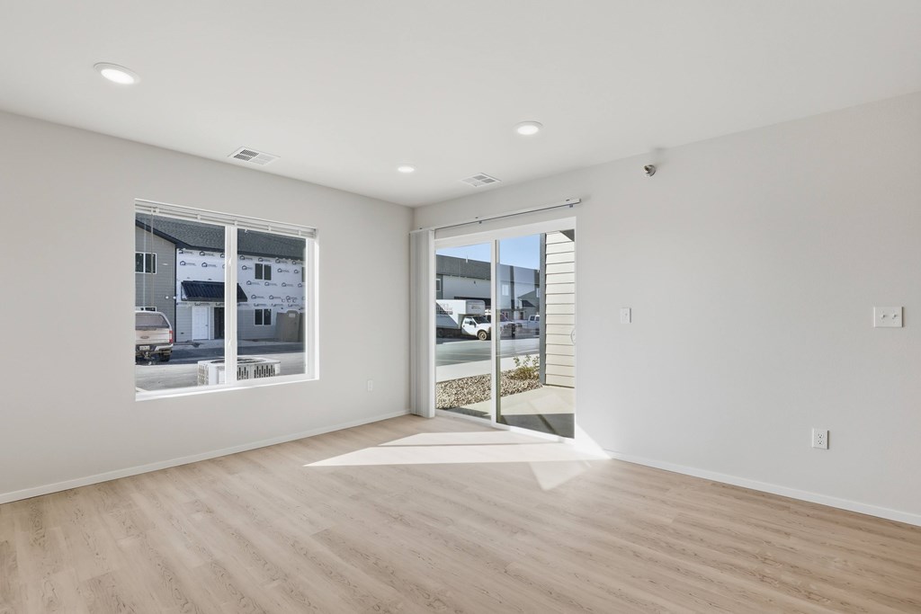 A room with a large window and a sliding glass door.