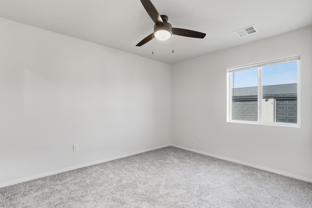 A room with a ceiling fan and a window.