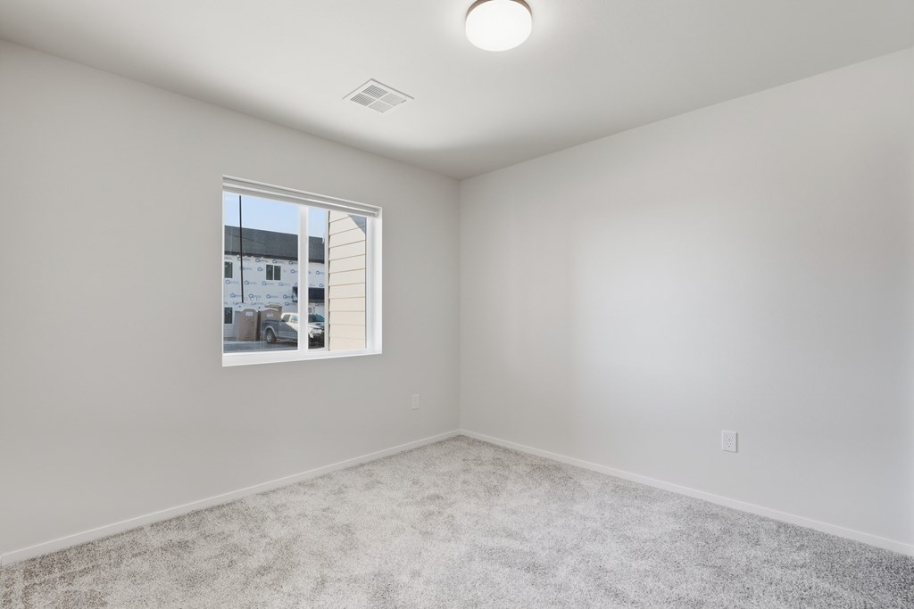A room with a window and carpeted floor.