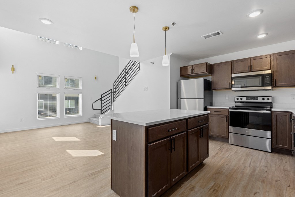 a kitchen with an island and stainless steel appliances and wooden cabinets