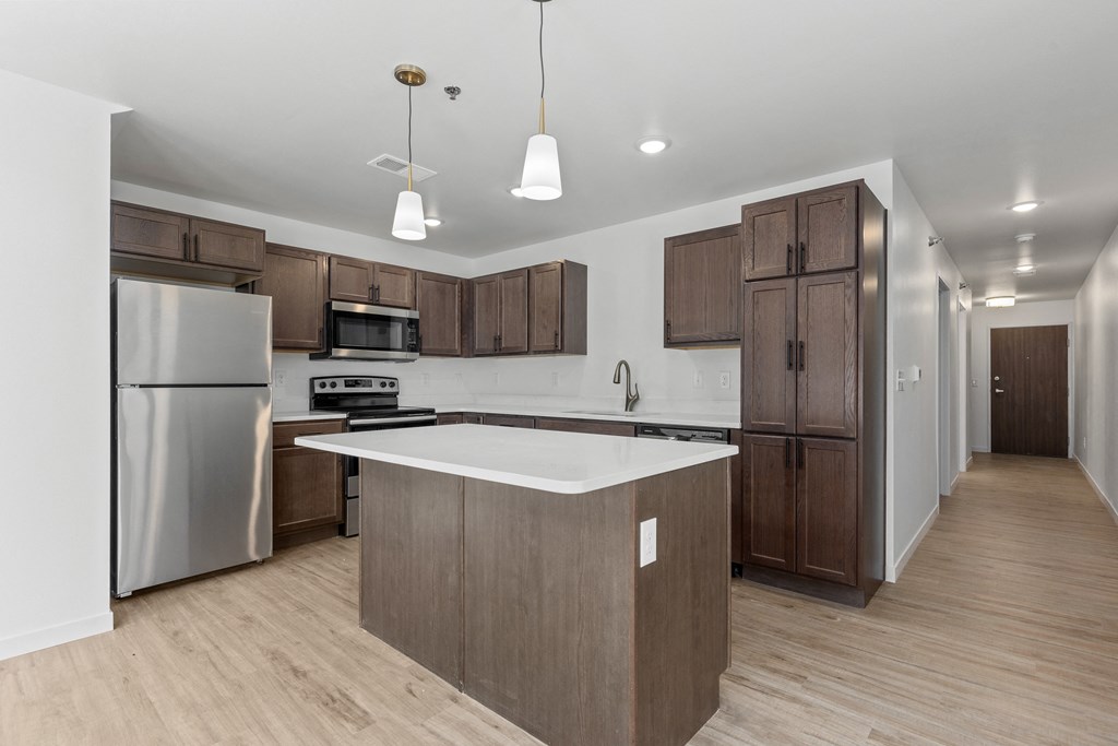 a large kitchen with stainless steel appliances and wooden cabinets