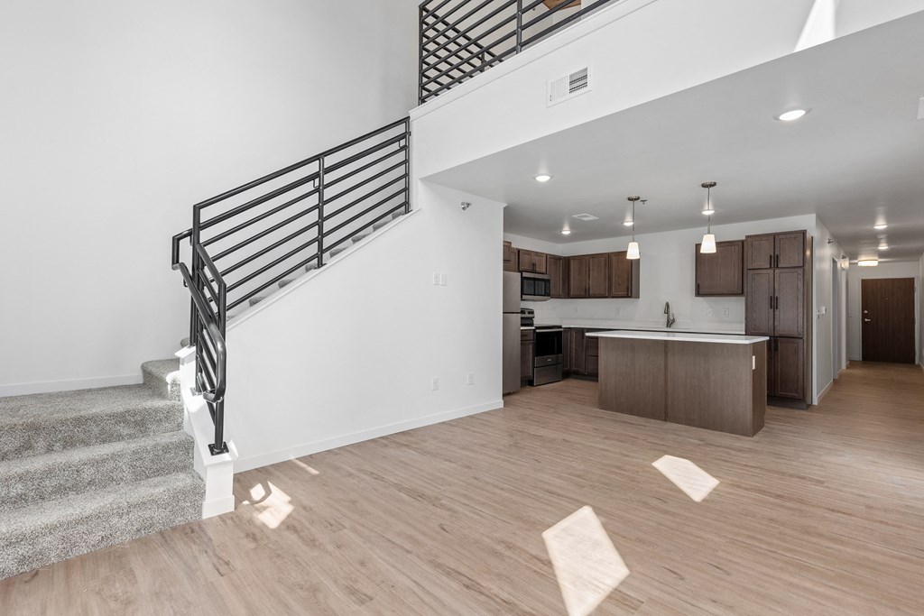 an open living room and kitchen with a staircase in a new home