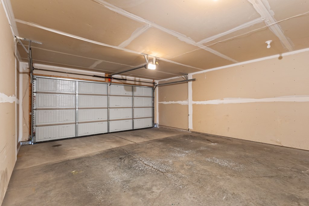 A large, empty garage with a concrete floor and white walls.