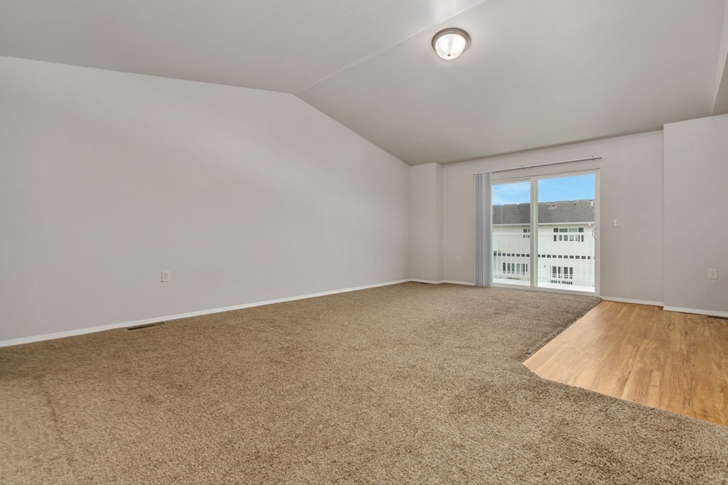 Empty room with carpeted floor and a window.