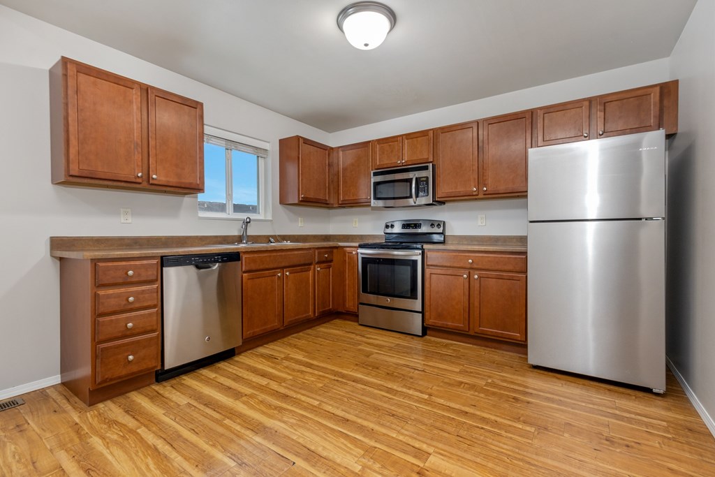 A kitchen with wooden cabinets and stainless steel appliances.