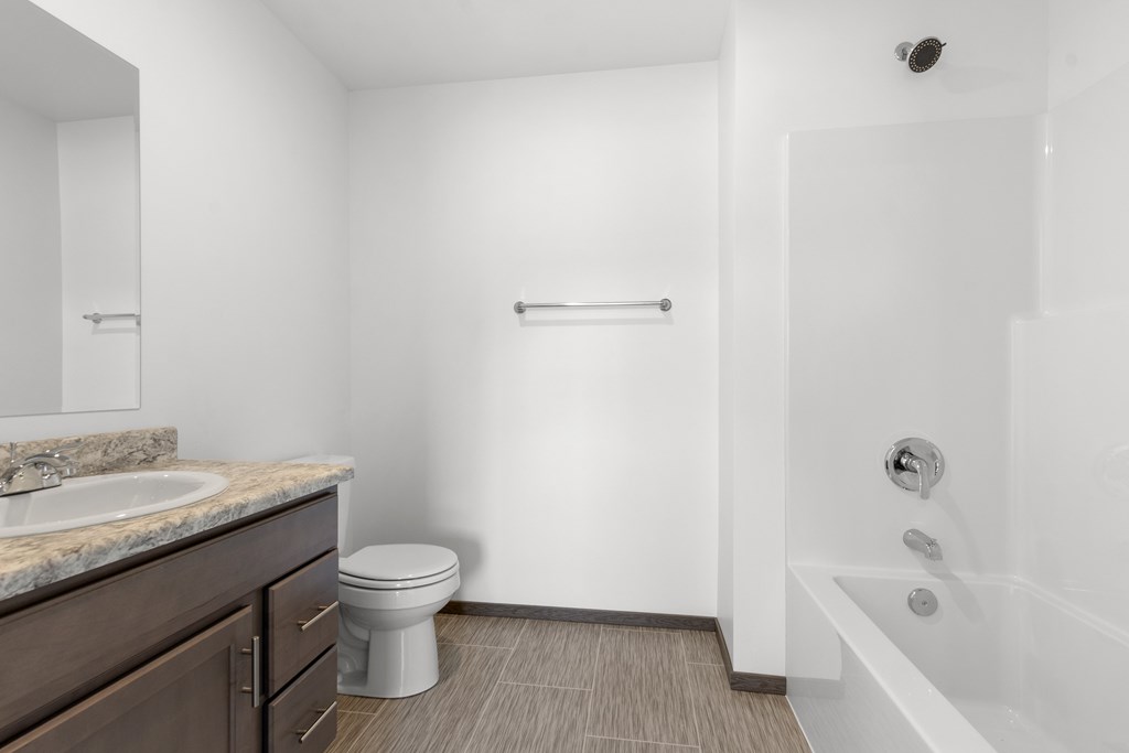 A white bathroom with a toilet, sink, and bathtub.