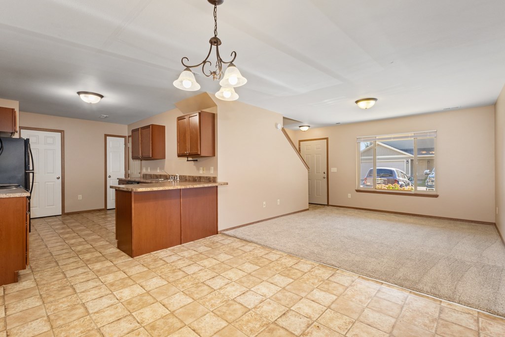 A kitchen area with a tile floor and a chandelier hanging from the ceiling.