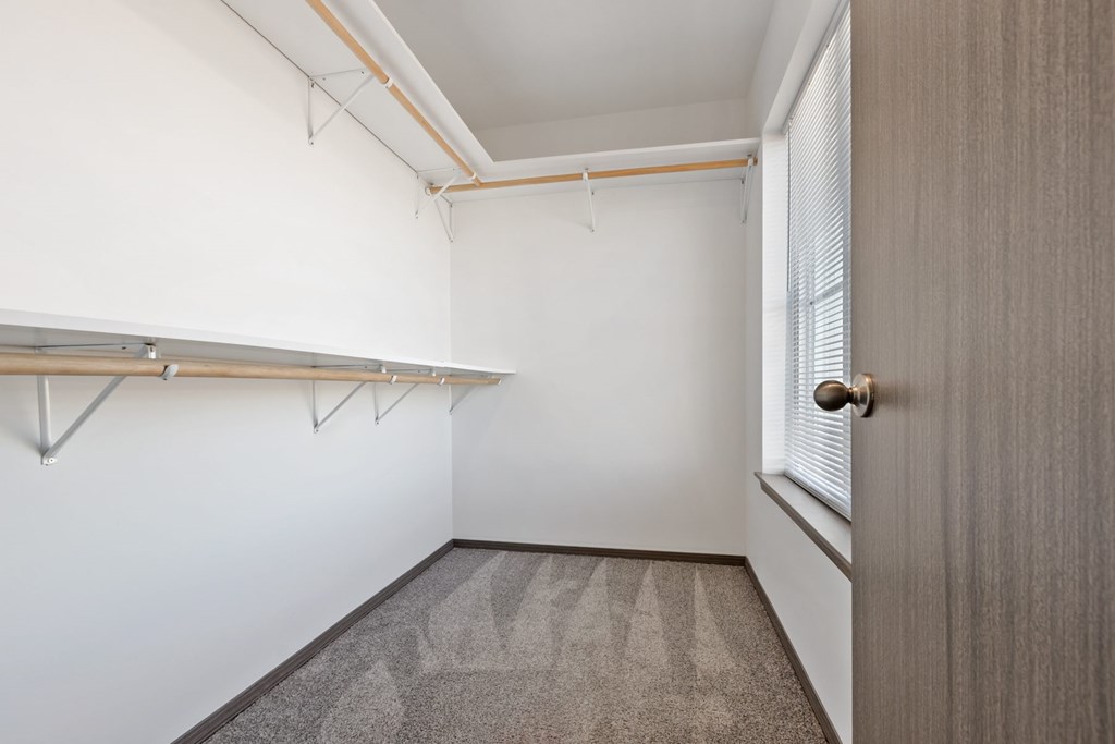 A room with a carpeted floor and a door on the right side.